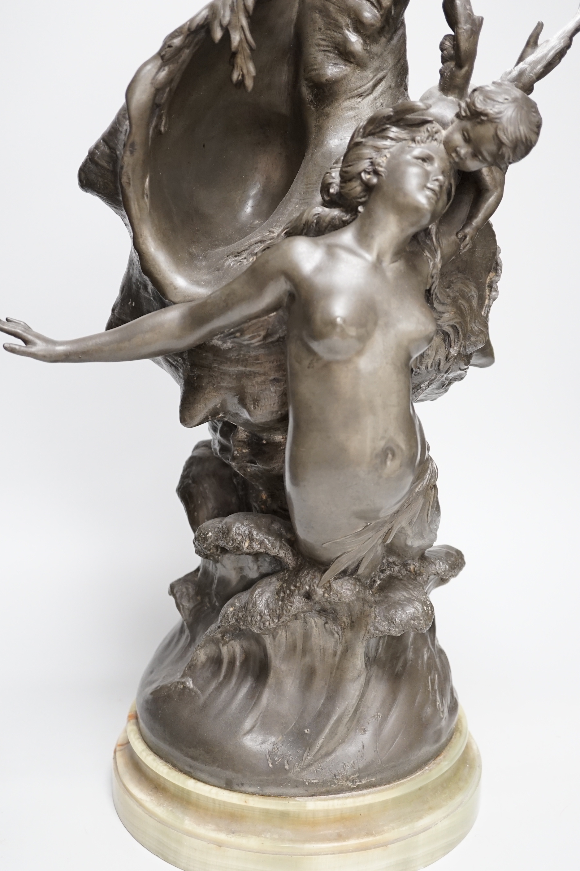 After H. Francois Moreau, a large spelter group of Cupid and a mermaid before a giant conch shell, signed, 64cm high